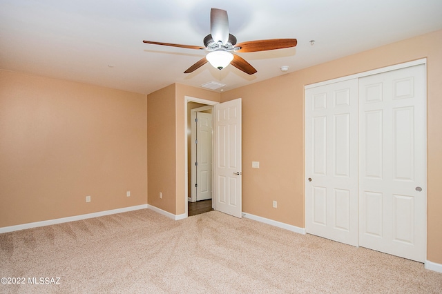 unfurnished bedroom featuring ceiling fan, light colored carpet, and a closet