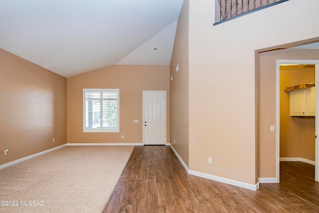 foyer entrance with vaulted ceiling and hardwood / wood-style floors