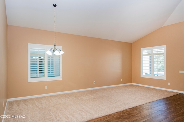 unfurnished room featuring hardwood / wood-style flooring, a notable chandelier, and lofted ceiling