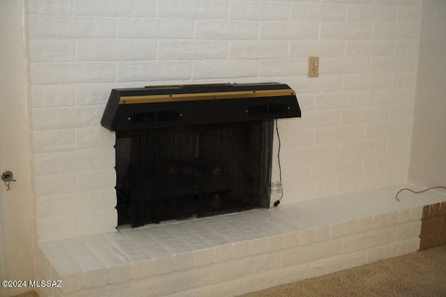 room details featuring a brick fireplace and speckled floor