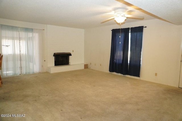 unfurnished living room featuring a ceiling fan, carpet, a fireplace, and a textured ceiling