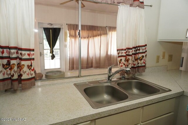 kitchen with light countertops, ceiling fan, and a sink