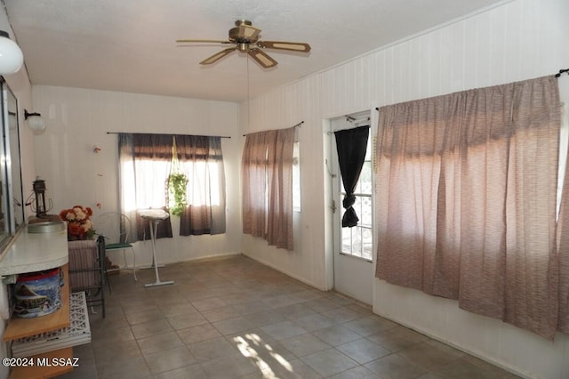 interior space with tile patterned floors and a ceiling fan