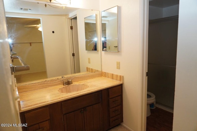 bathroom with visible vents, toilet, and vanity