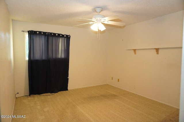 unfurnished room featuring light carpet, a textured ceiling, and a ceiling fan