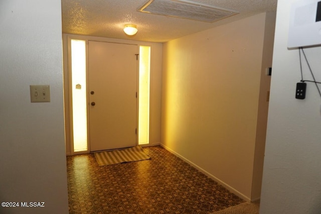 entryway with baseboards, visible vents, and a textured ceiling