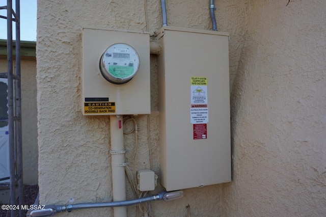 exterior details featuring electric meter and stucco siding