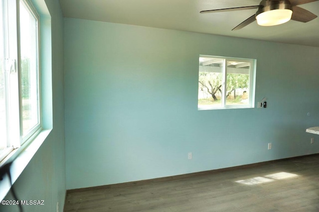 unfurnished room with a healthy amount of sunlight, ceiling fan, and wood finished floors