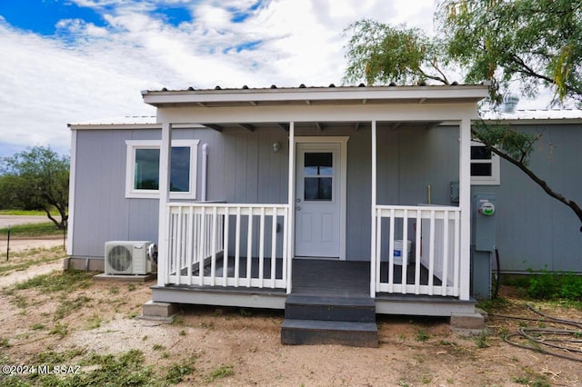 exterior space with metal roof, covered porch, and ac unit