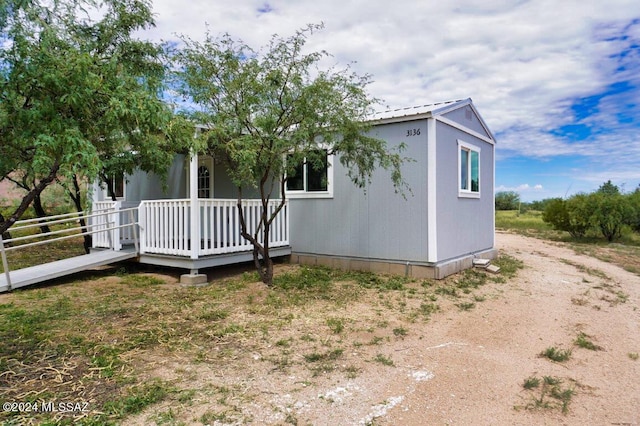 exterior space featuring driveway and metal roof
