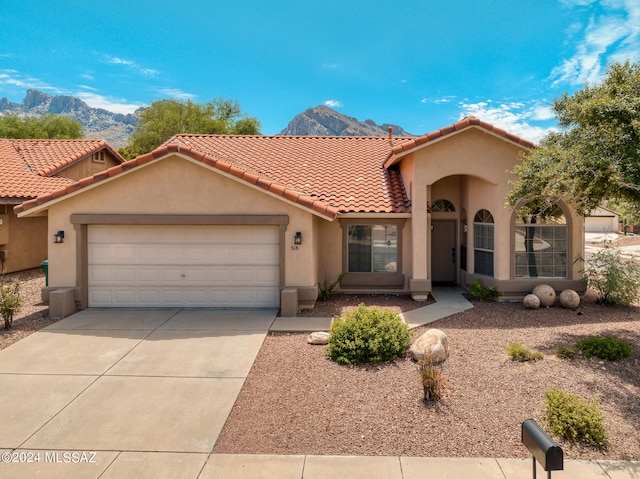 mediterranean / spanish-style home with a mountain view and a garage