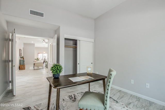 office space featuring visible vents, ceiling fan, light wood-style flooring, and baseboards