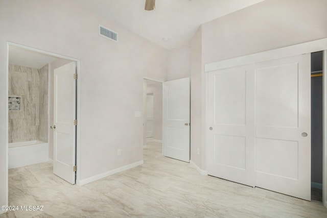 unfurnished bedroom featuring a closet, visible vents, a ceiling fan, ensuite bath, and baseboards