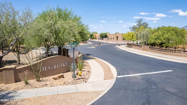 view of street featuring sidewalks, traffic signs, a gated entry, and curbs