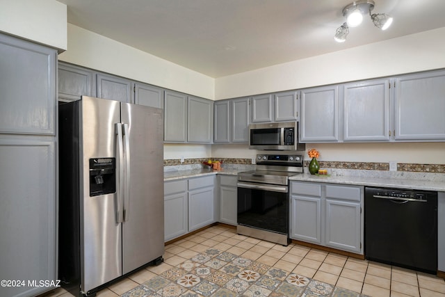 kitchen featuring light tile patterned floors, stainless steel appliances, and gray cabinets