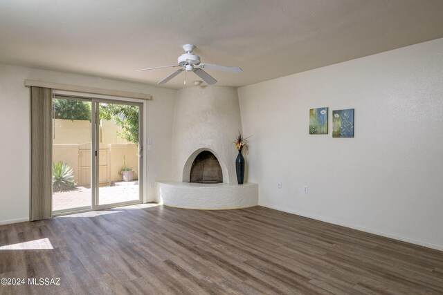 unfurnished living room with ceiling fan, wood-type flooring, and a fireplace