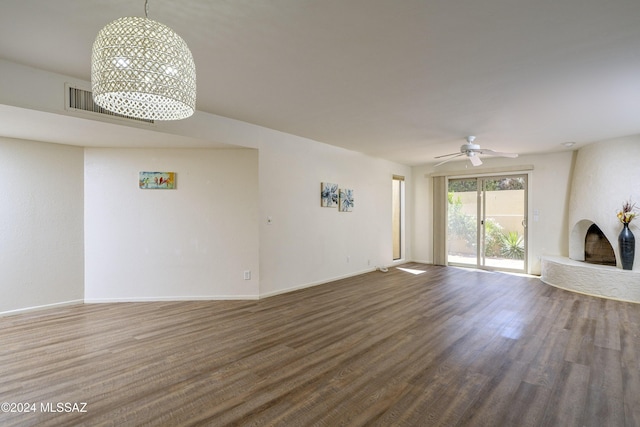 unfurnished living room featuring a large fireplace, hardwood / wood-style flooring, and ceiling fan