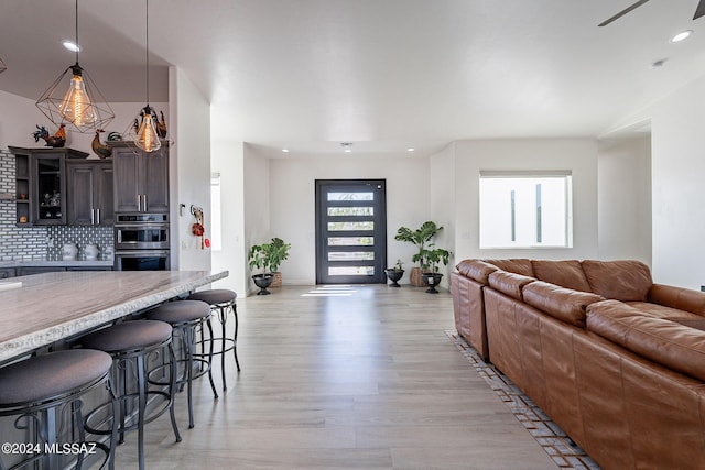 living area with light wood-style flooring and recessed lighting