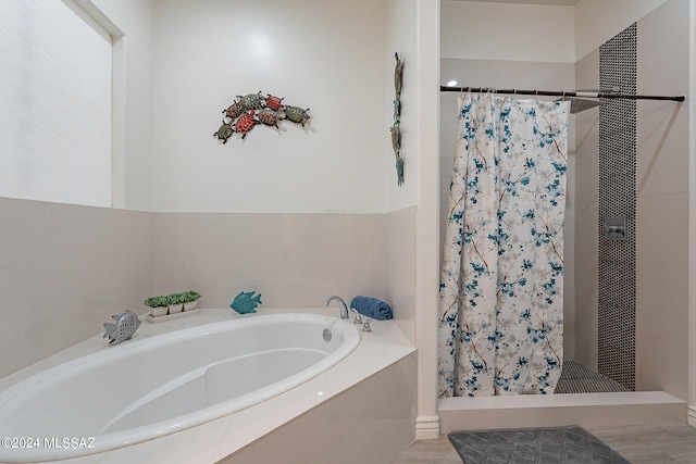 bathroom with a shower stall and a bath