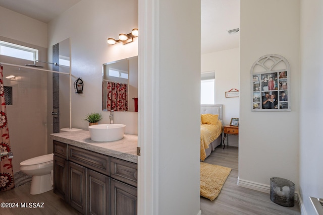 full bath with toilet, visible vents, connected bathroom, and wood finished floors