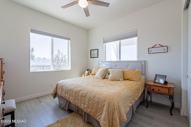 bedroom with ceiling fan, baseboards, and wood finished floors