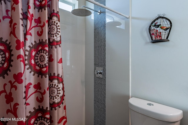 bathroom featuring a tile shower and toilet