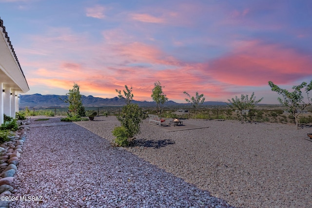 yard at dusk with a mountain view and a patio