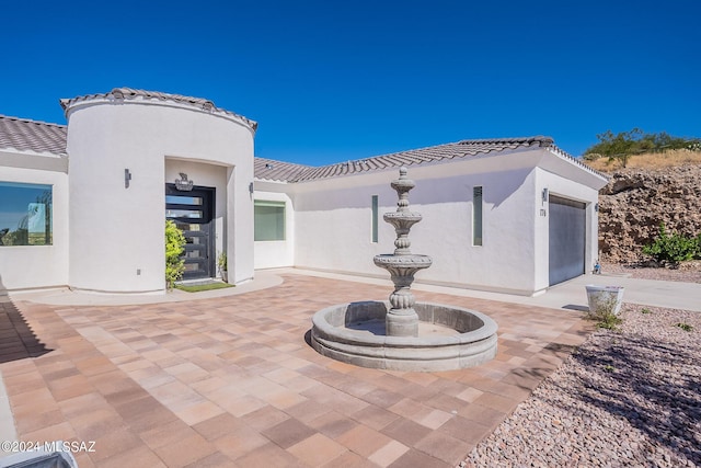 exterior space featuring a tile roof and stucco siding