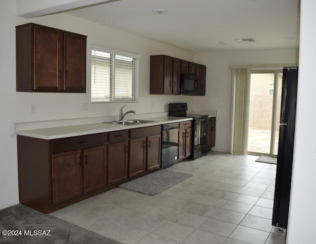 kitchen featuring light countertops, visible vents, a sink, and black appliances