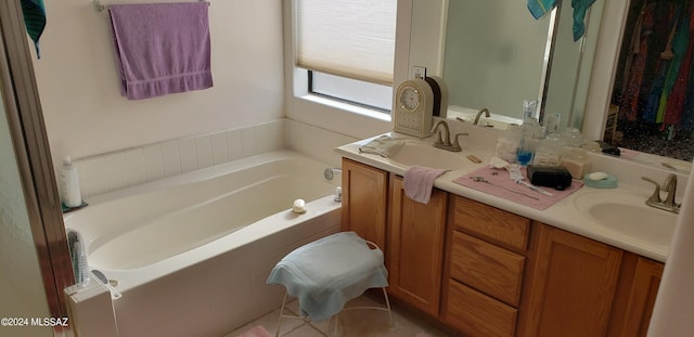 bathroom featuring double vanity, a garden tub, and a sink