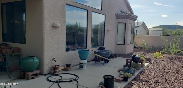 view of patio / terrace featuring fence and a mountain view
