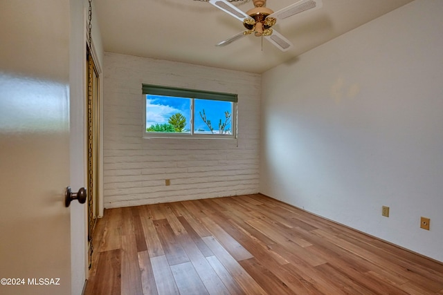 empty room with ceiling fan and light hardwood / wood-style floors