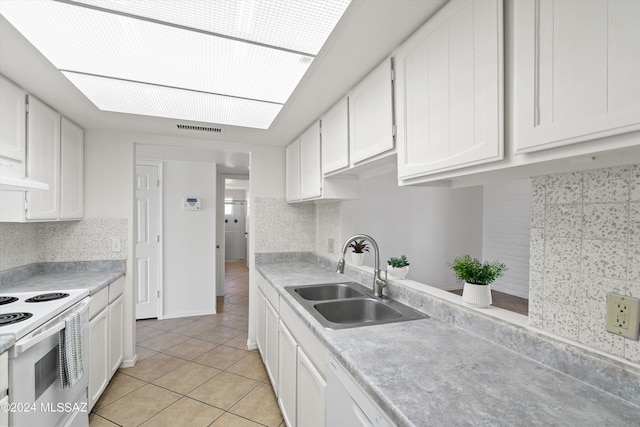 kitchen with sink, light tile patterned floors, white cabinetry, white range with electric stovetop, and tasteful backsplash