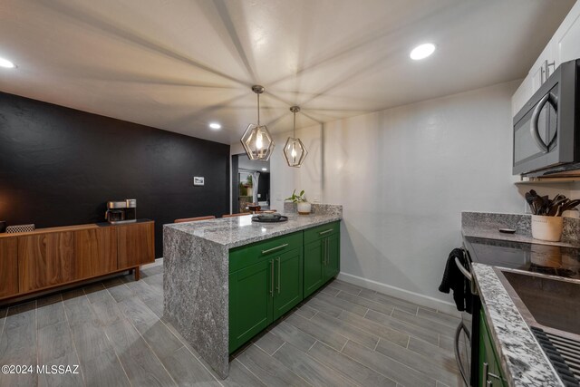 kitchen with light stone counters, light wood-type flooring, green cabinetry, kitchen peninsula, and hanging light fixtures