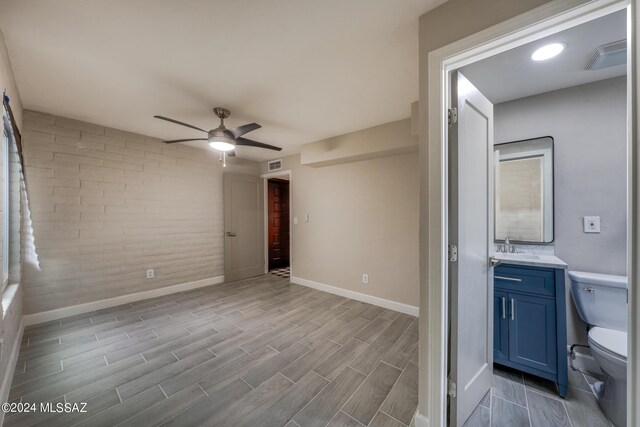 interior space with sink, ceiling fan, and ensuite bath