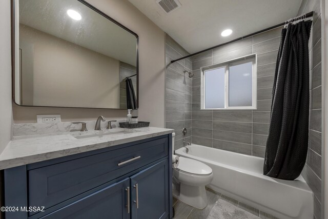 full bathroom with tile patterned floors, vanity, shower / tub combo, and toilet