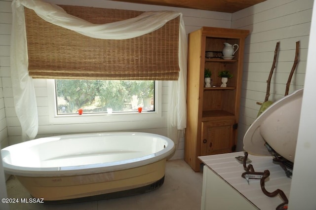 bathroom with wood walls and a bathing tub