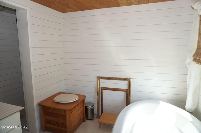 bathroom with wooden ceiling and a bathing tub