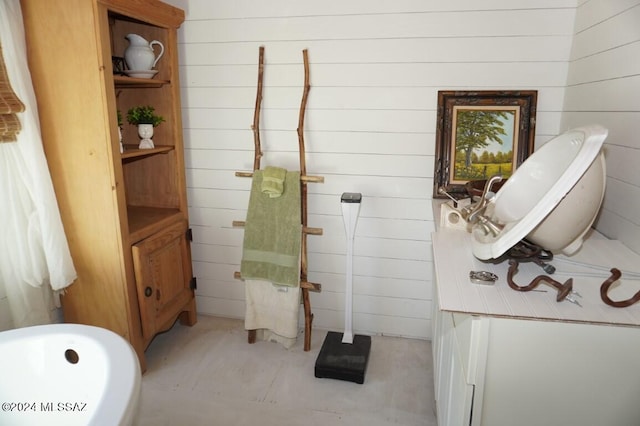 bathroom with a bath and wood walls