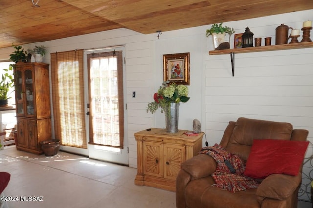 sitting room featuring wooden walls and wooden ceiling
