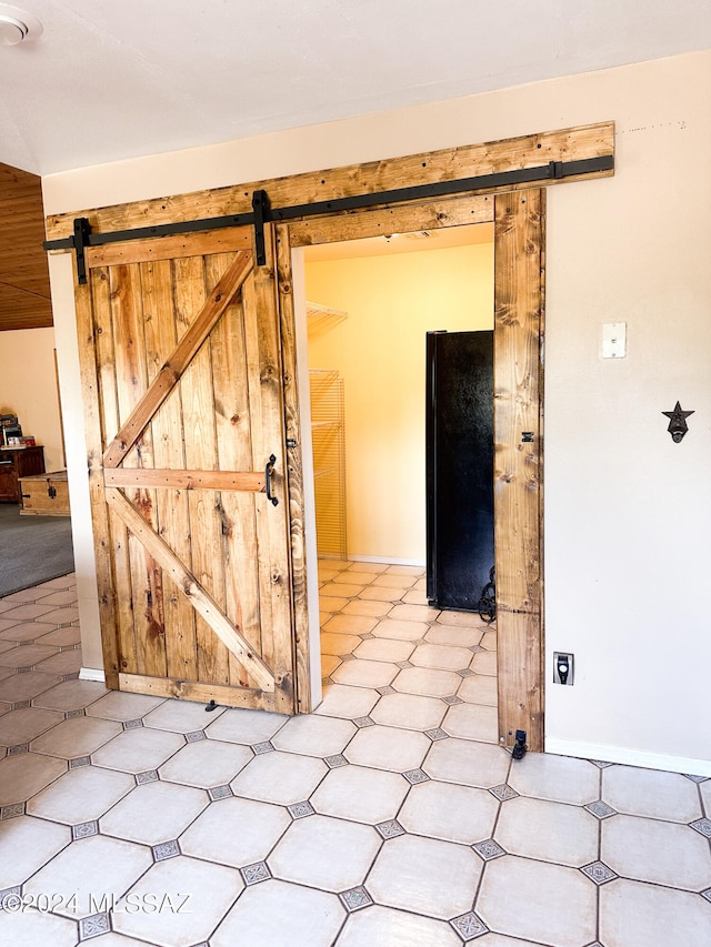 interior space with light tile patterned floors and a barn door