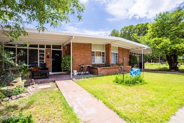 single story home with a porch, a front lawn, and brick siding