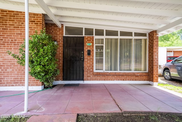 property entrance featuring brick siding