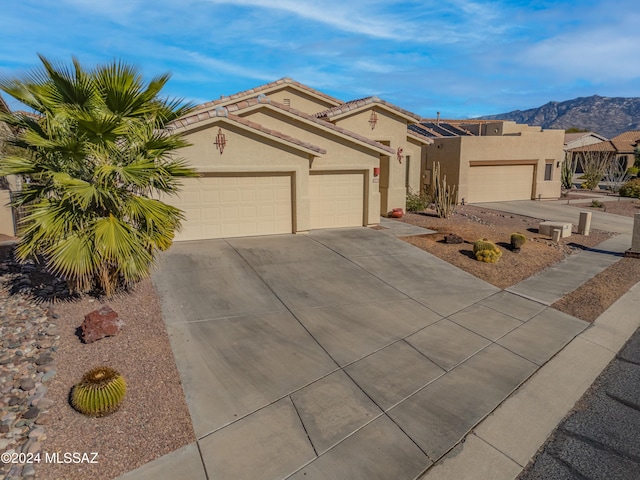 view of front of property with a mountain view and a garage