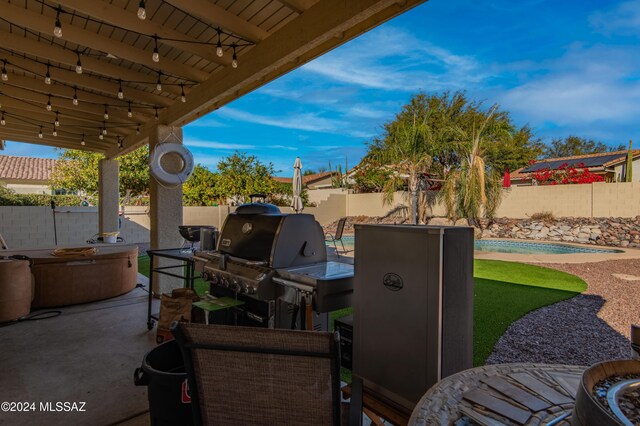 view of patio / terrace with area for grilling, a pool, and exterior kitchen