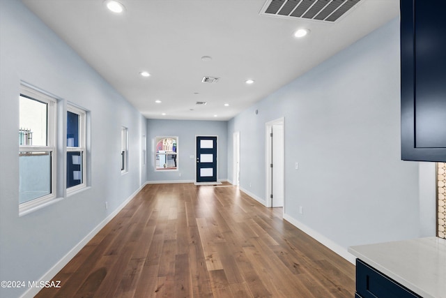 hallway with dark wood-type flooring and a wealth of natural light