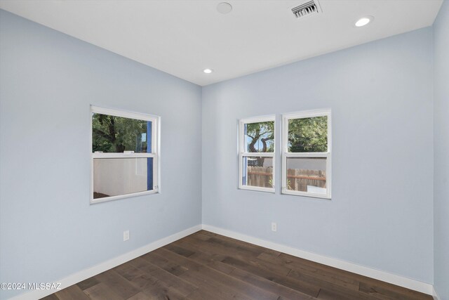 unfurnished room with dark wood-type flooring