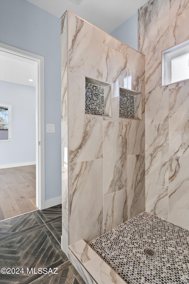 bathroom featuring plenty of natural light and tiled shower