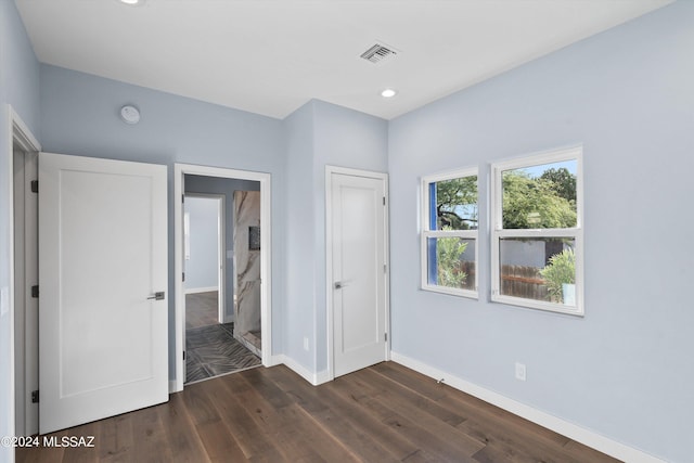 unfurnished bedroom with dark hardwood / wood-style flooring