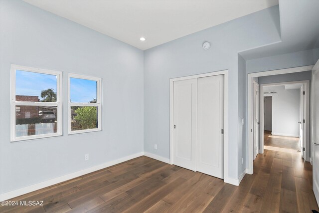 unfurnished bedroom featuring dark hardwood / wood-style flooring and a closet